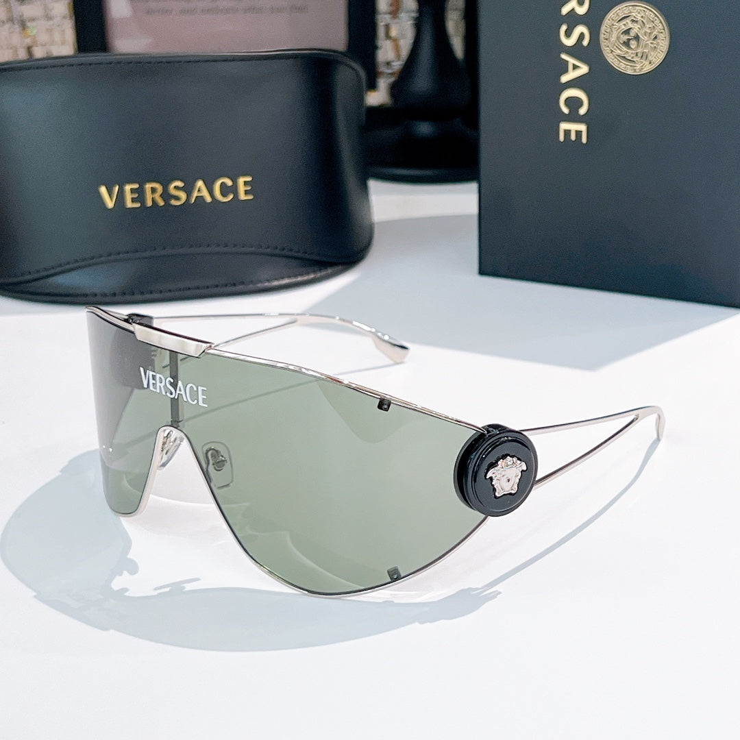 Sunglasses with gold-tone frame and green mirrored lenses, round black logo details.