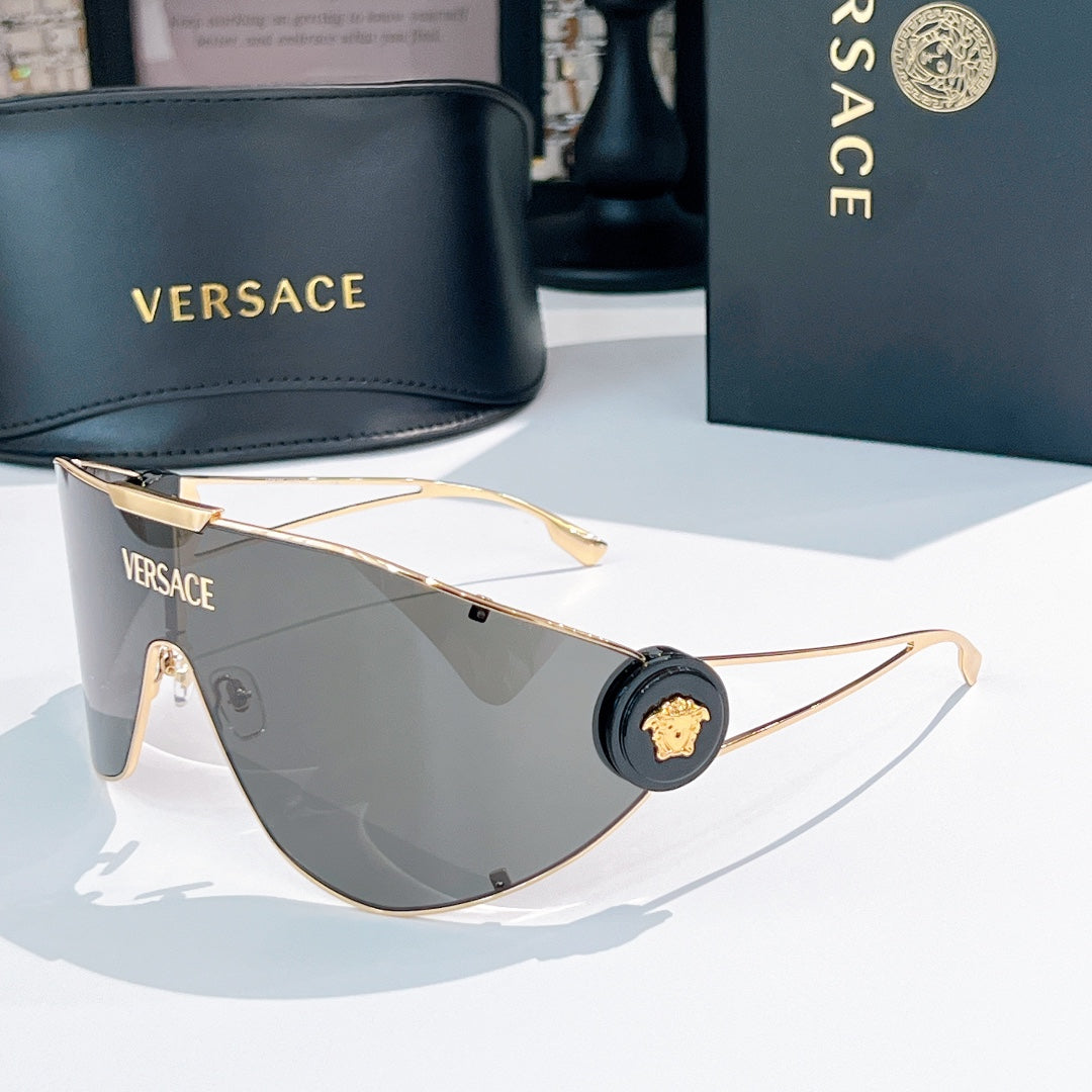 Sunglasses with gold-tone frame and dark green mirrored lenses, round black logo detail.