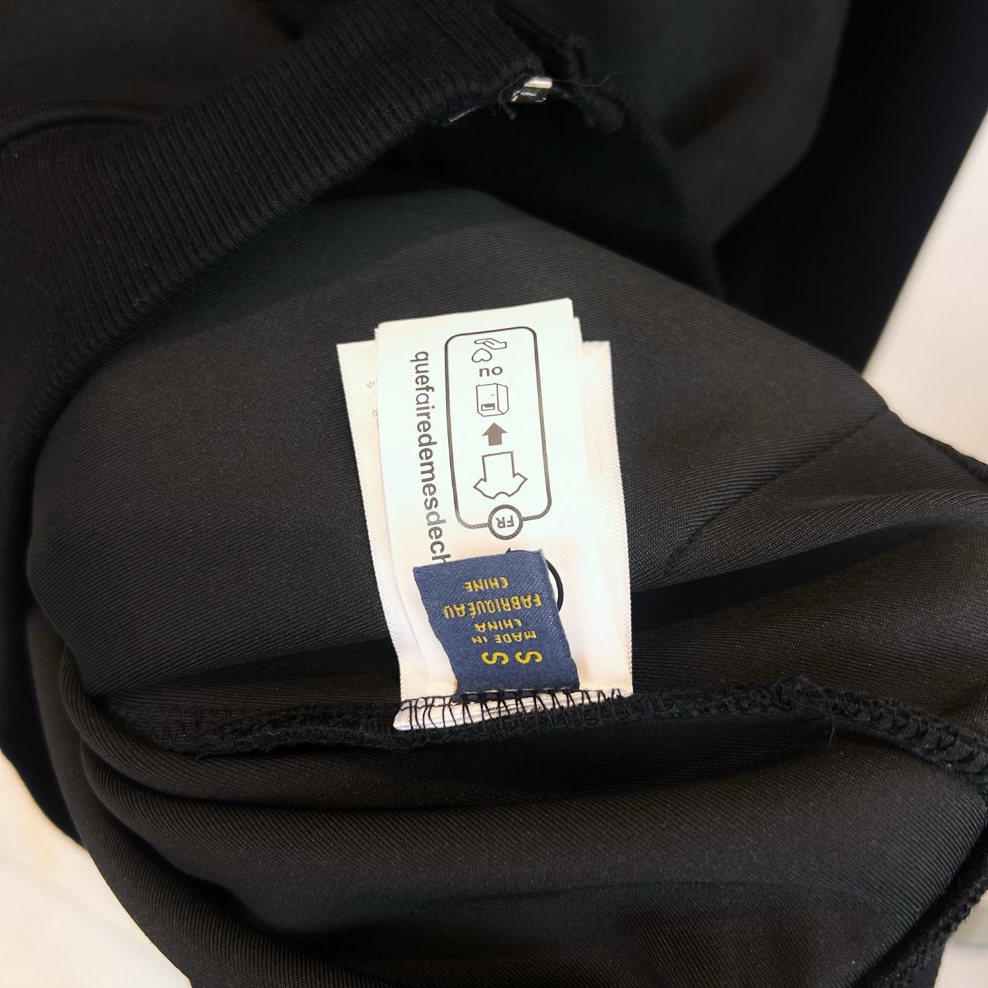 Dark hoodie fabric and size care label inside collar area