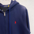 Navy zip-up hoodie close-up with red polo logo on chest