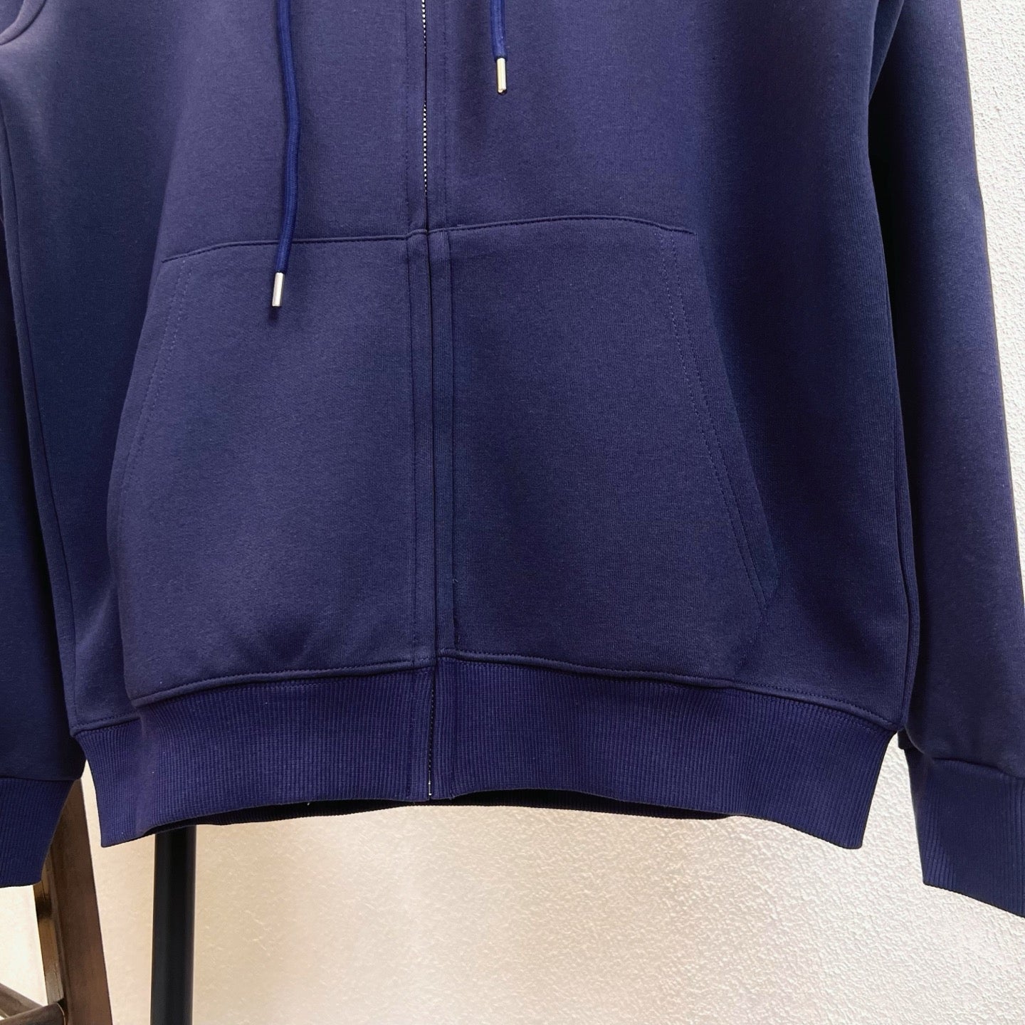 Navy zip-up hoodie close-up of front zipper and drawstrings
