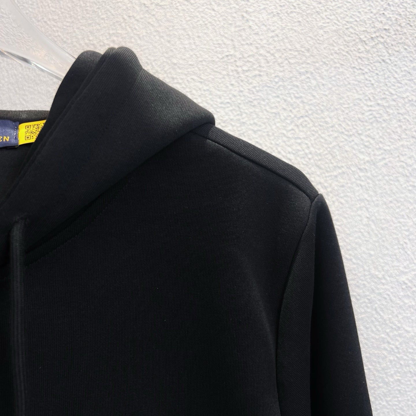 Black hoodie shoulder and hood detail, zip-up style