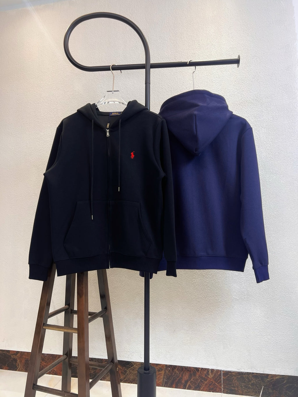 Zip-up hoodie pair in black and navy, both with red polo logo