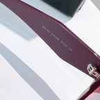 Burgundy sunglass temple with printed model and size markings