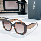 Black sunglasses with clear lenses and orange tortoise-style frame details