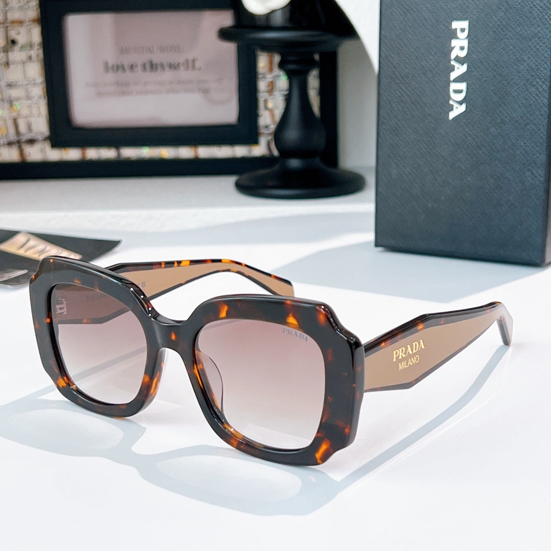 Black sunglasses with clear lenses and orange tortoise-style frame details
