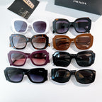 Assorted Prada sunglasses with colored frames and tinted lenses, shown together