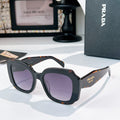 Black sunglasses with purple-tinted lenses and orange tortoise-style accents