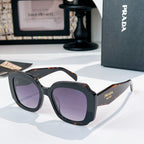 Black sunglasses with purple-tinted lenses and orange tortoise-style accents