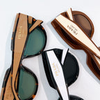 Prada sunglasses with tortoiseshell and black frames, tinted lenses.