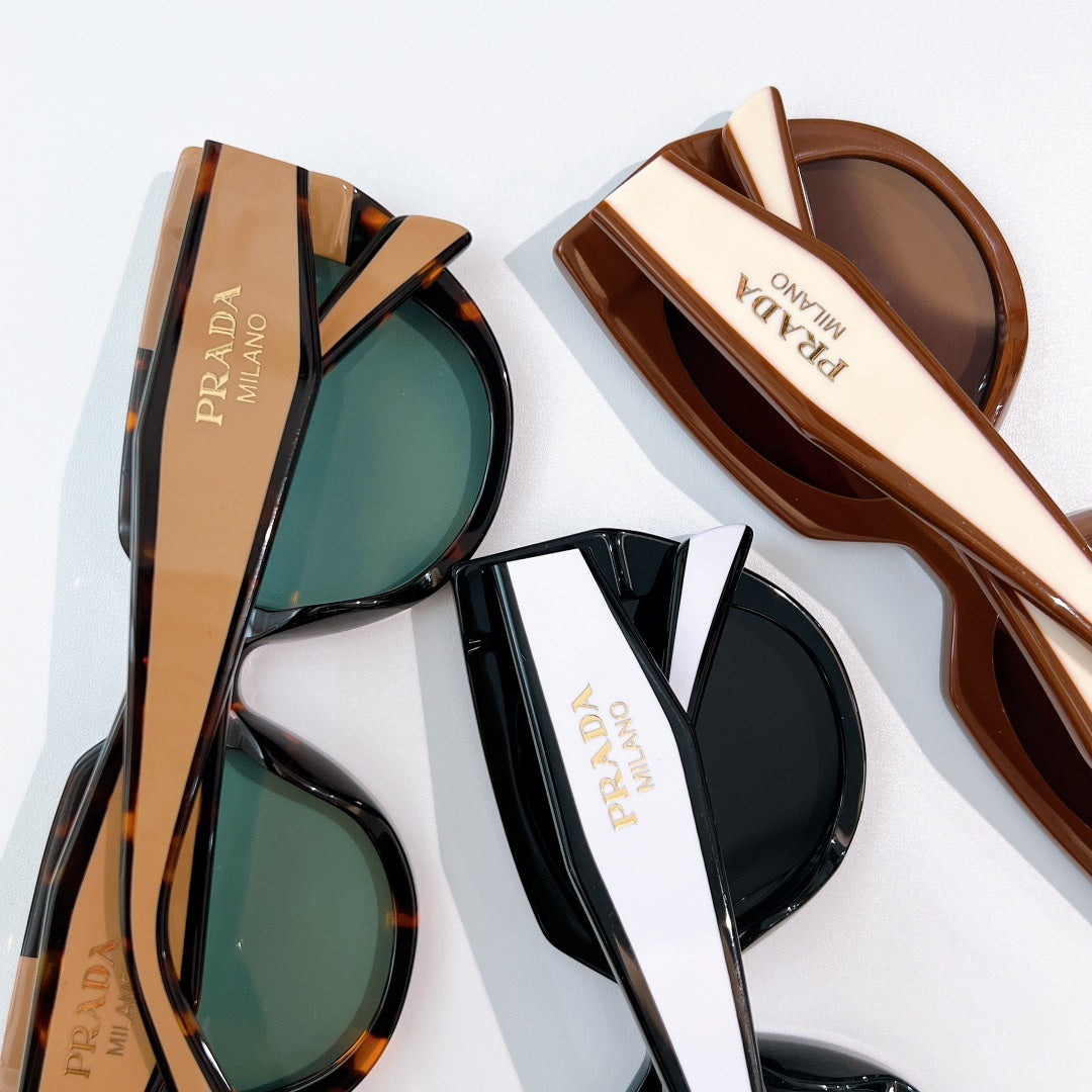 Prada sunglasses with tortoiseshell and black frames, tinted lenses.
