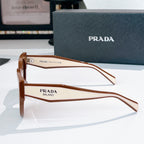 Prada sunglasses side view with brown frames and tinted lenses.