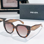 Prada sunglasses with tortoiseshell and black frames, tinted lenses.