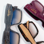Assorted Prada square sunglasses with blue, maroon, and tortoise frames in clear covers.