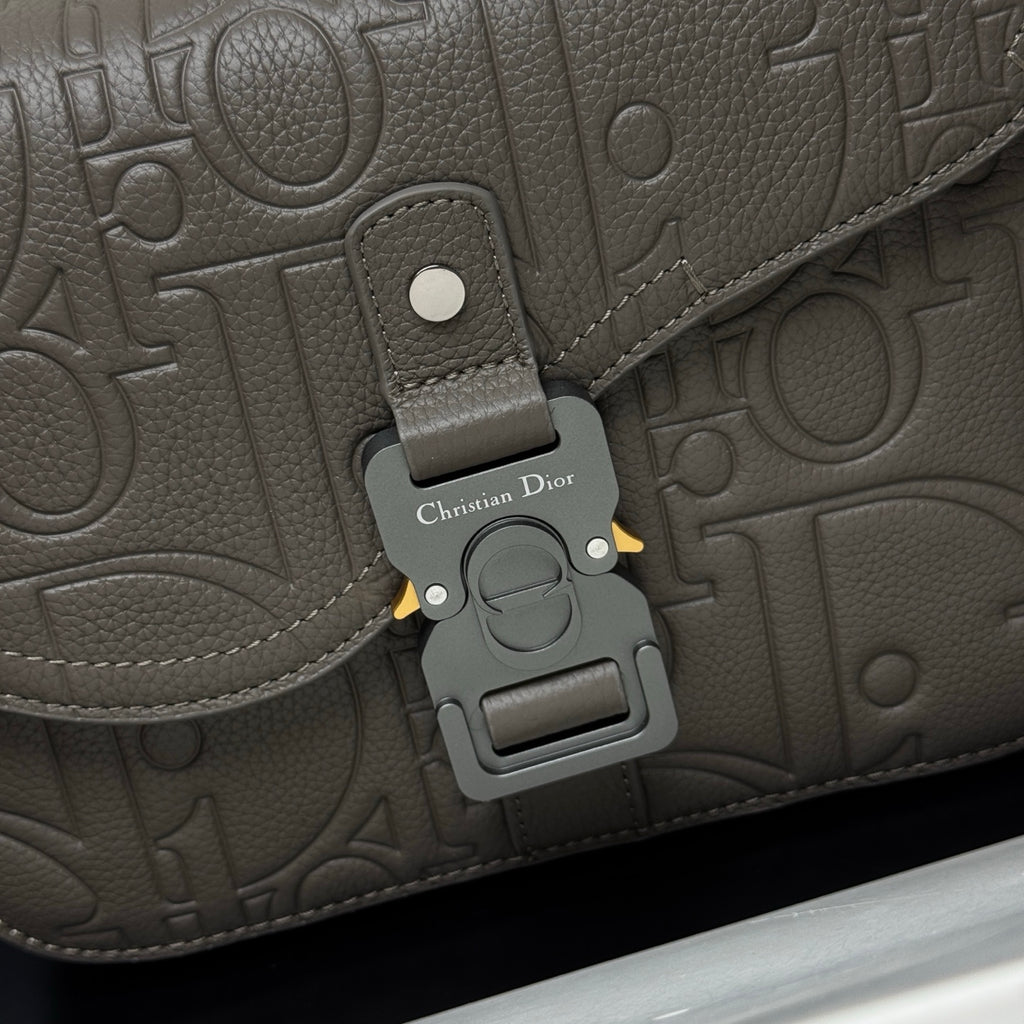 Dior embossed flap close-up with buckle clasp and metal snap hardware