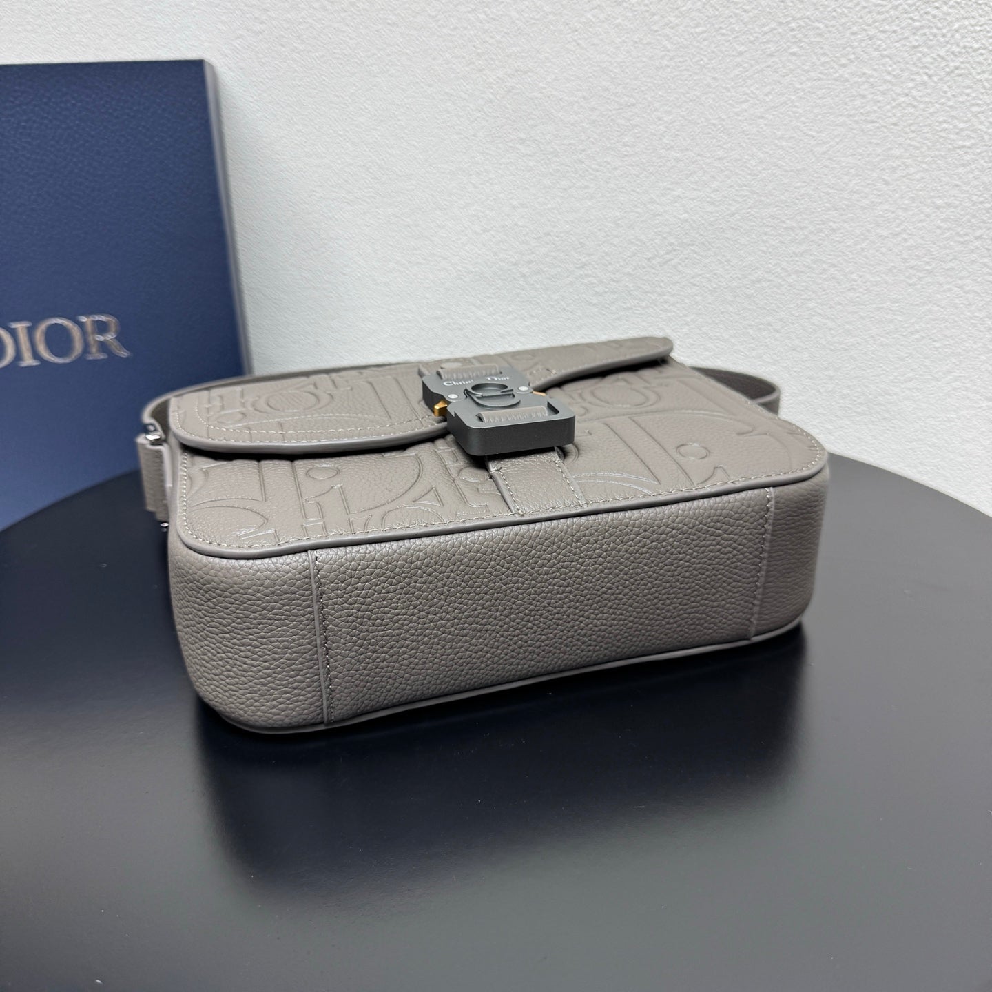 Dior grained leather bag with embossed pattern and front buckle closure