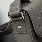 Dior bag strap close-up with round snap button and stitched leather tab