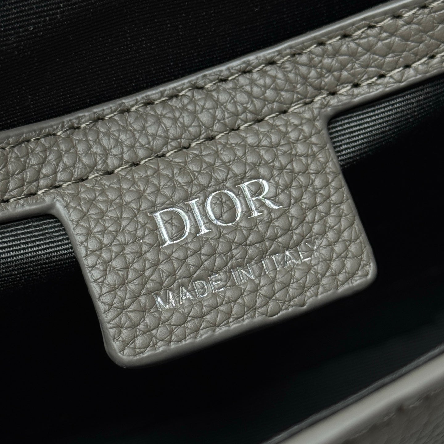 Dior logo leather patch on embossed bag with 'MADE IN ITALY' text