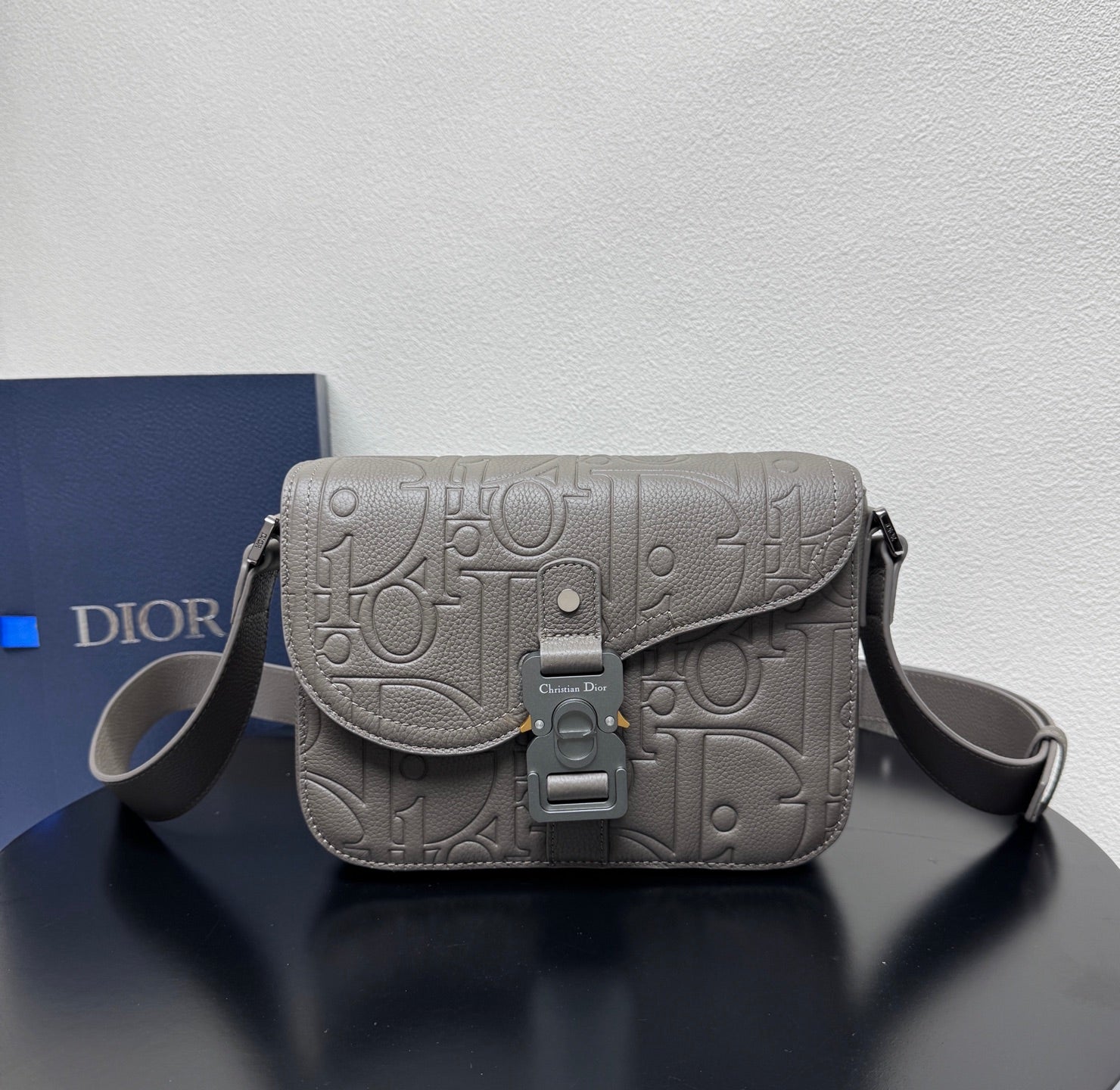 Dior embossed shoulder bag with flap, top buckle clasp, and adjustable crossbody strap