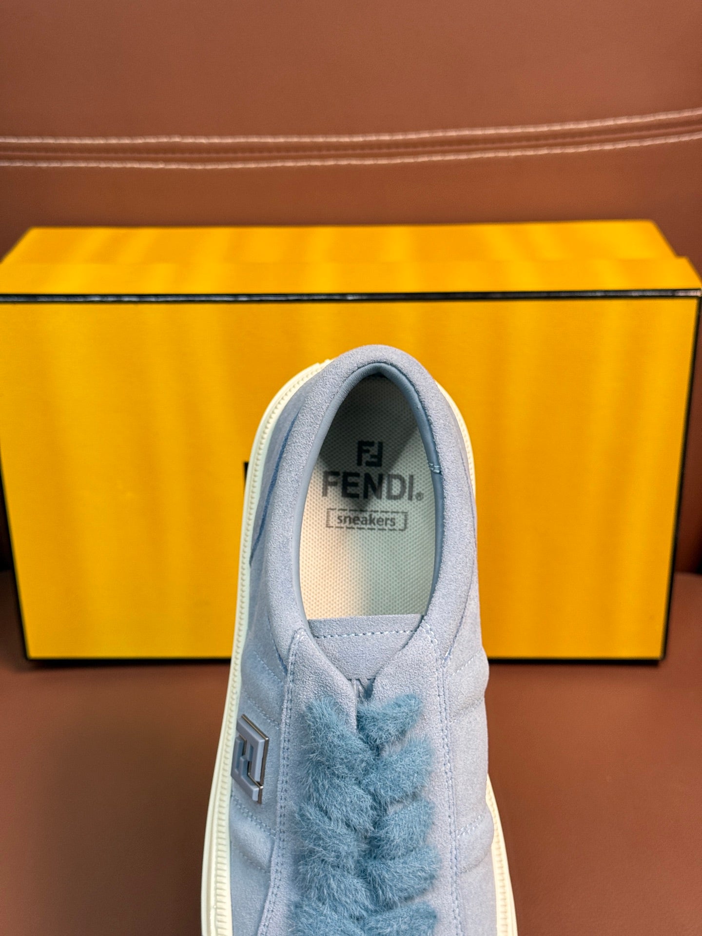 Fendi unisex light-blue sneaker tongue close-up with FENDI Fendi logo text