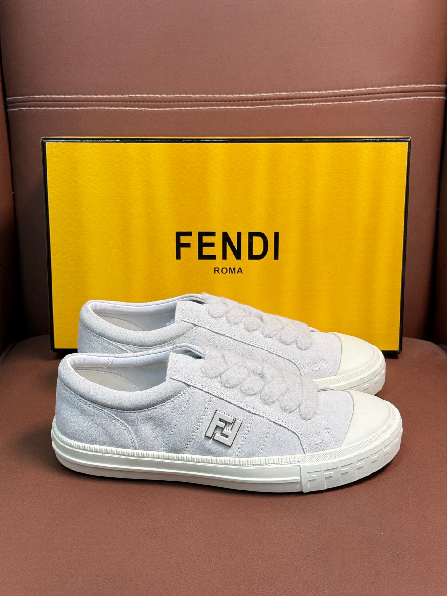 White Fendi unisex sneakers, front view with embossed logo and textured white sole