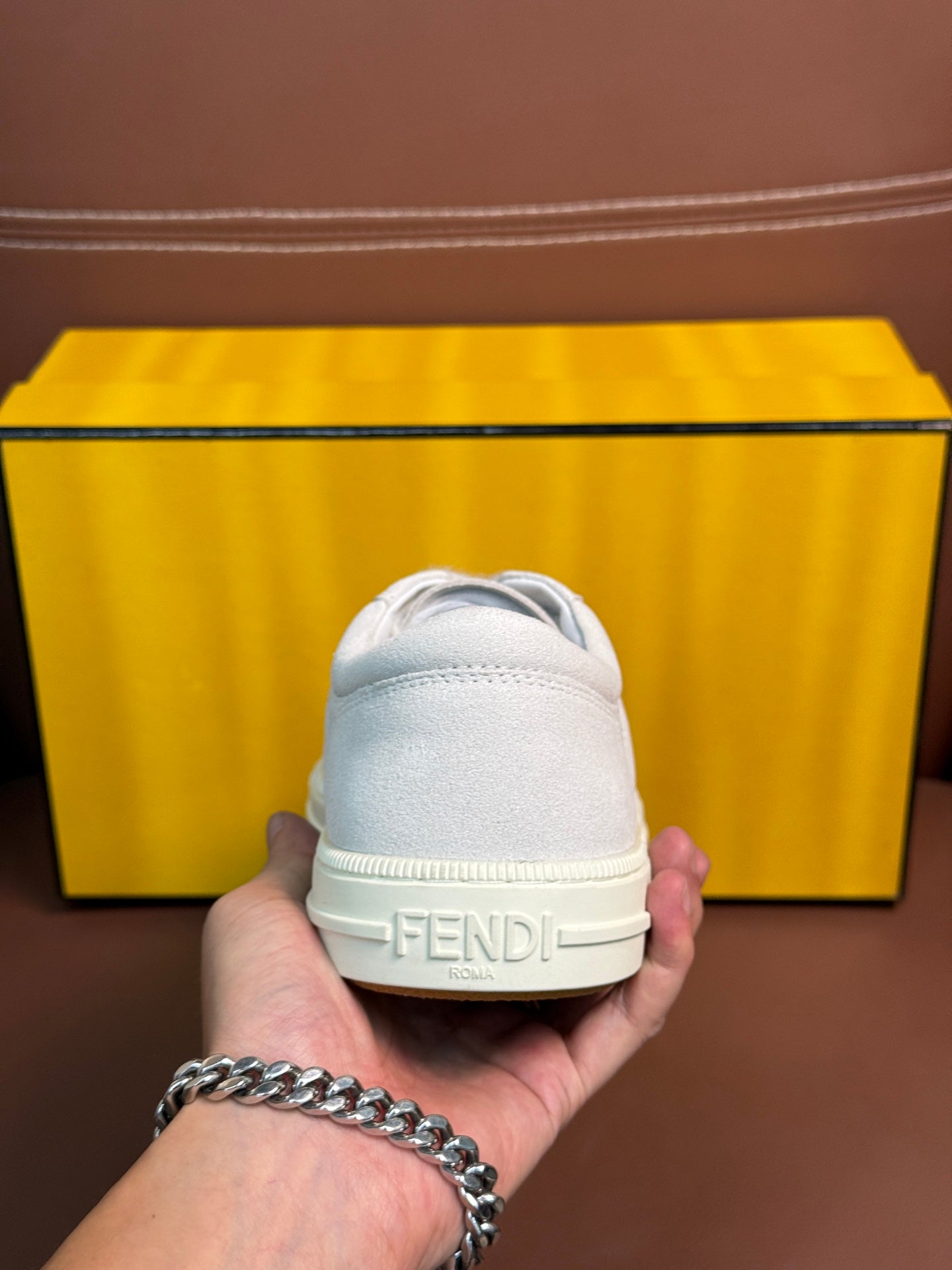 White Fendi unisex sneakers, heel close-up with Fendi logo on the back tab