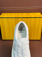 White Fendi unisex sneaker, close-up of tongue with Fendi logo and lace detailing