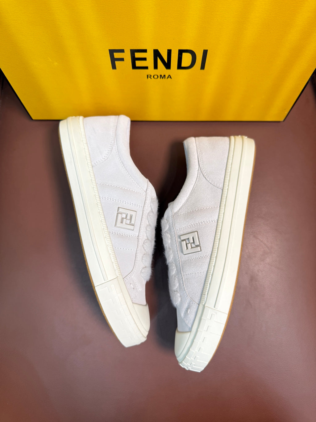 White Fendi unisex sneakers, front three-quarter view with square logo on the side