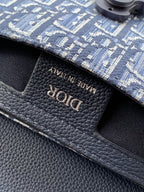 Dior logo embossed on textured navy leather bag flap