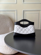 Chanel quilted mini handbag in black and white, front view with top handle