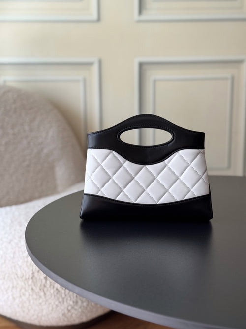 Chanel quilted mini handbag in black and white, front view with top handle