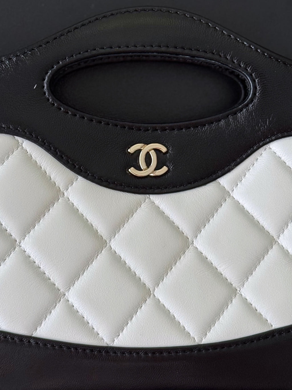 Chanel quilted handbag close-up of top handle opening with CC logo