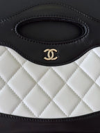 Chanel quilted handbag close-up of top handle opening with CC logo