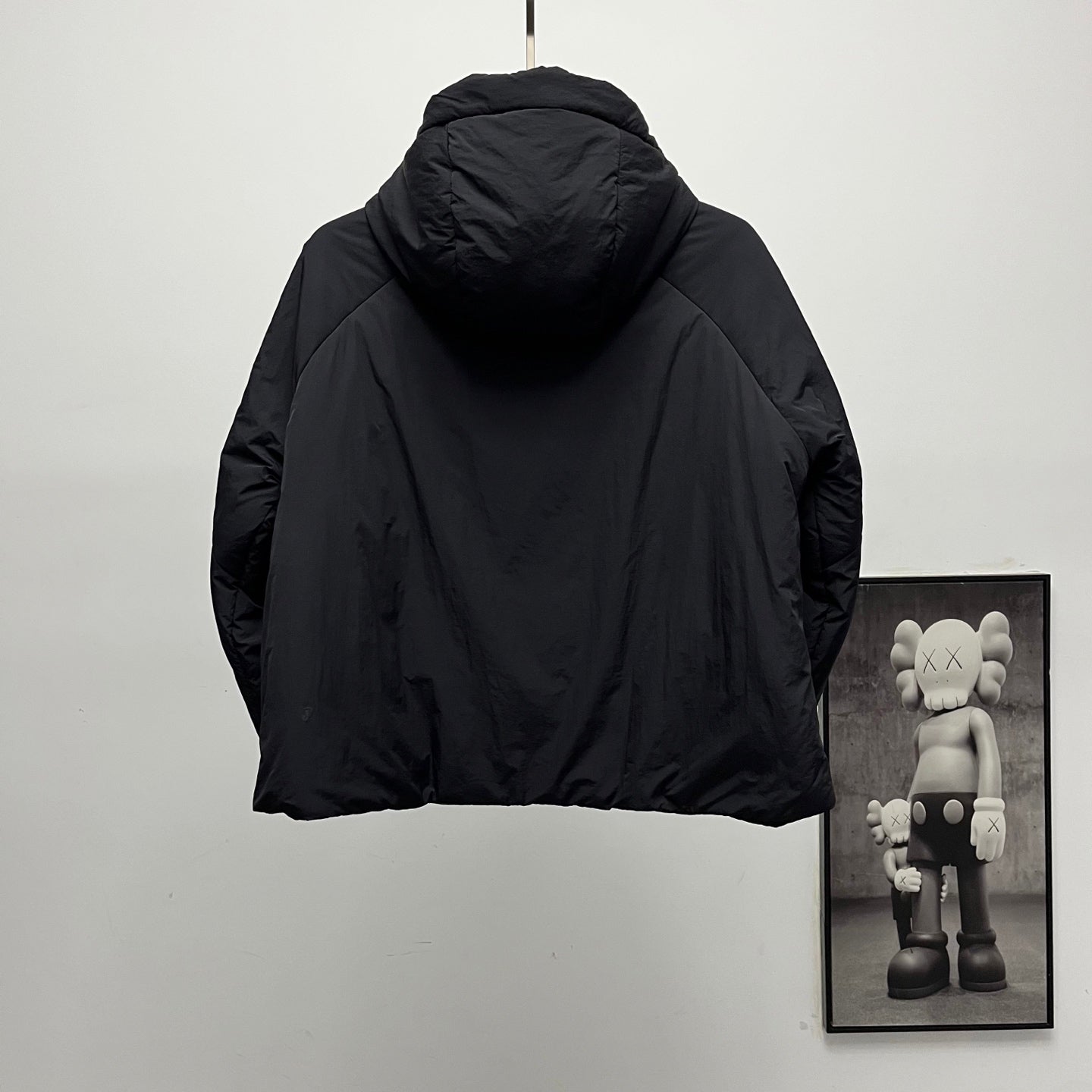 Back of black hooded puffer jacket with curved shoulders