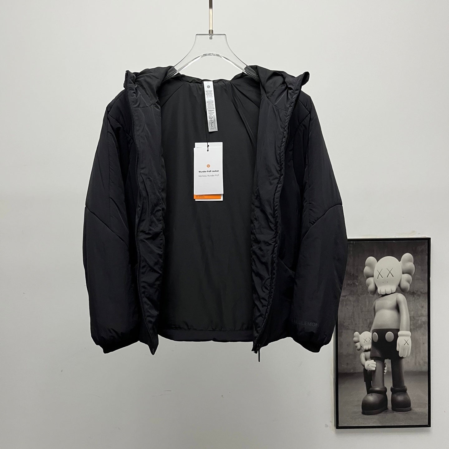 Black hooded puffer jacket with hanging neck label tag