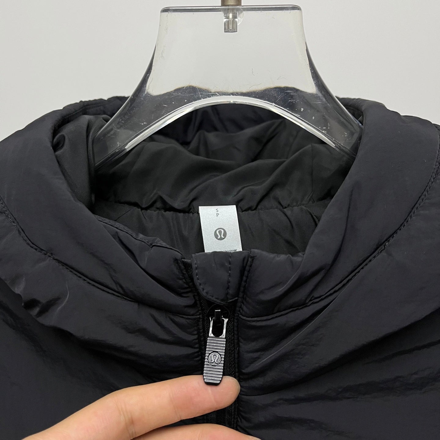 Black puffer jacket collar with visible zipper pull
