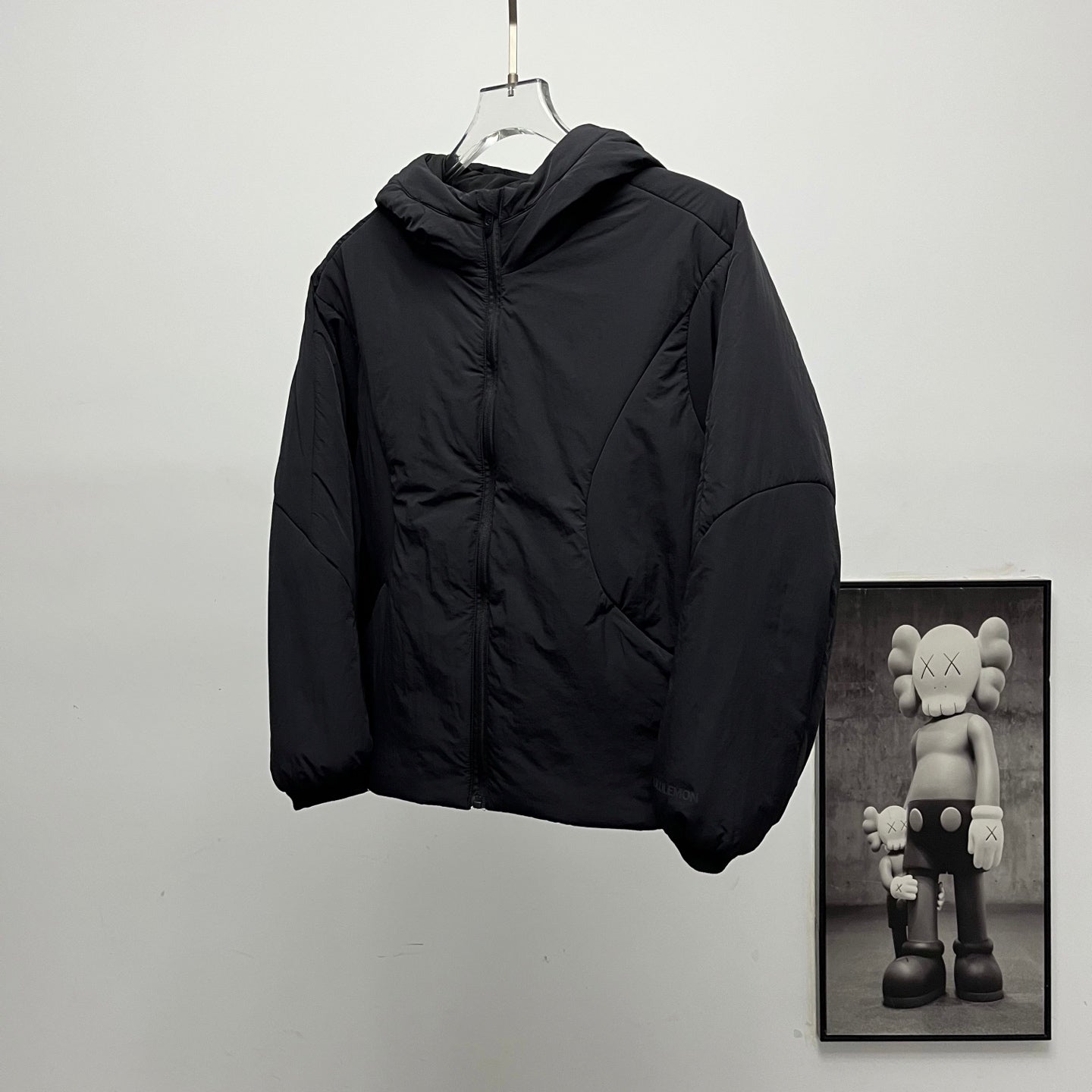 Black hooded puffer jacket, front view with zipper