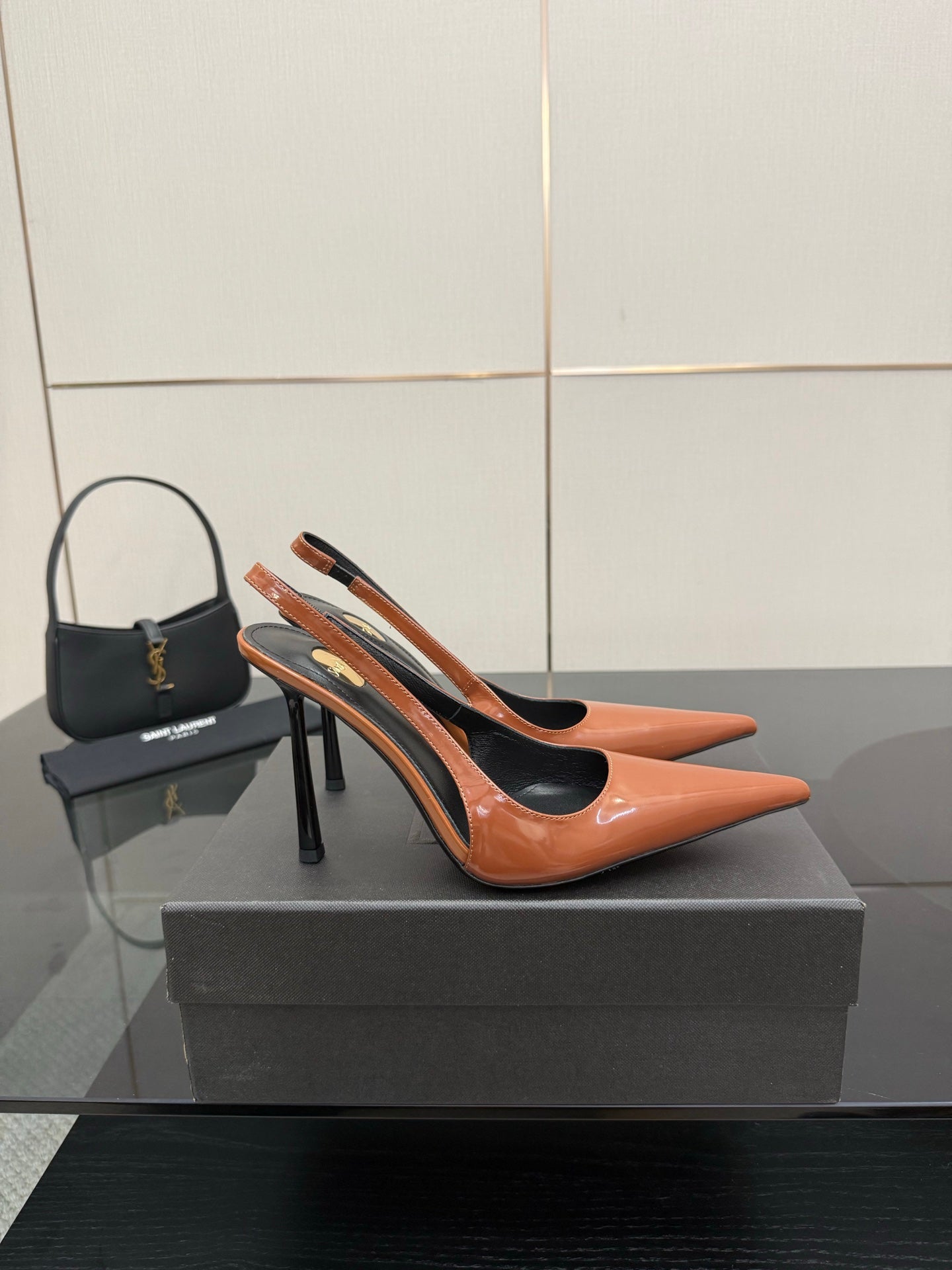 Ladies' YSL two-tone orange-and-black pointed-toe pumps with stiletto heels, side view