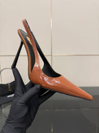 Ladies' YSL orange pointed-toe pumps with black heel and stiletto heel, close view