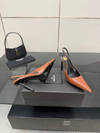 Ladies' YSL orange-and-black pointed-toe pumps with stiletto heels, angled view