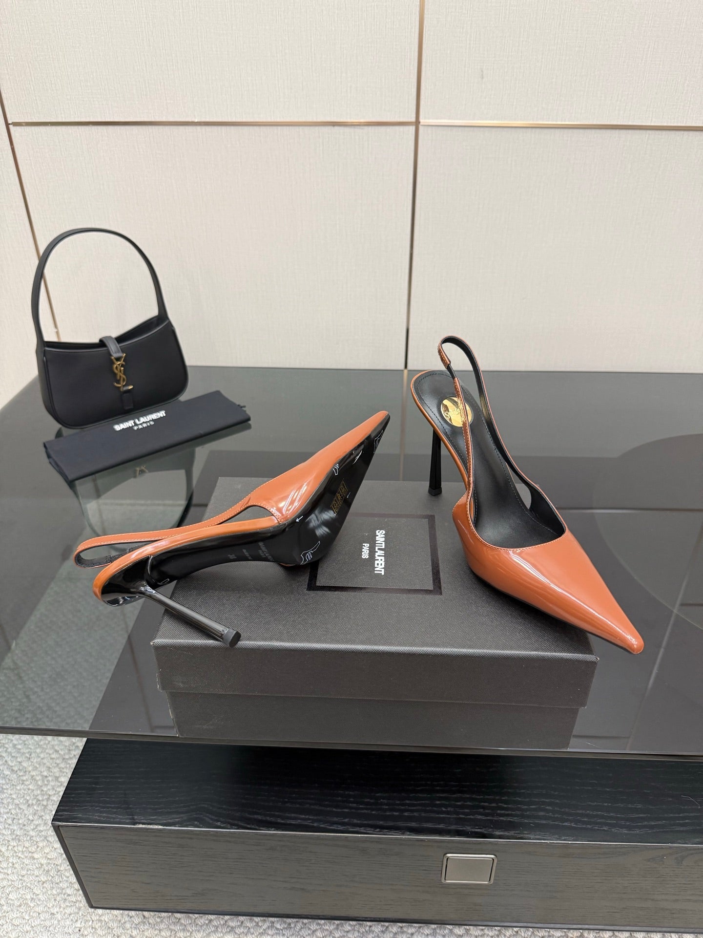 Ladies' YSL orange-and-black pointed-toe pumps with stiletto heels, angled view