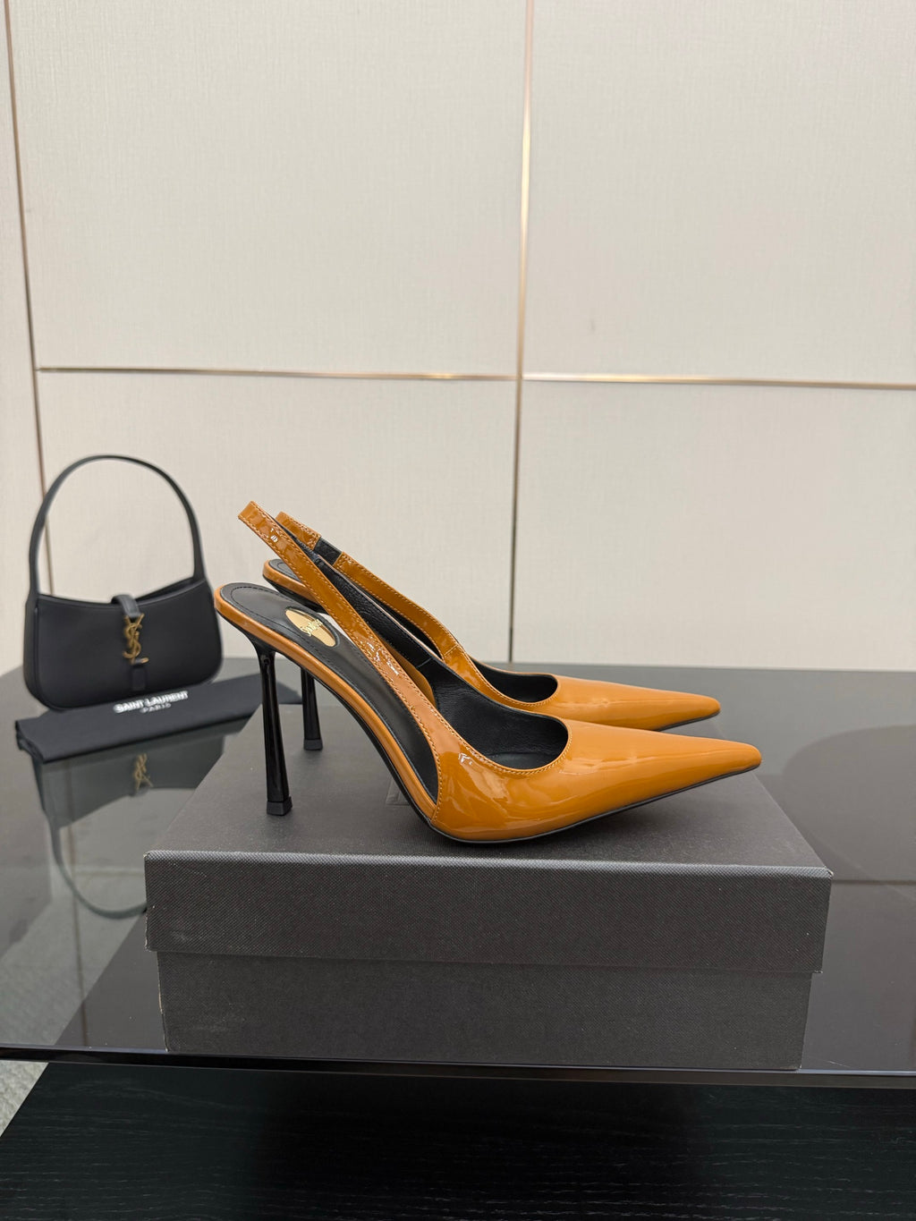 Women's orange-and-black slingback pumps with high stiletto heel and gold detail.