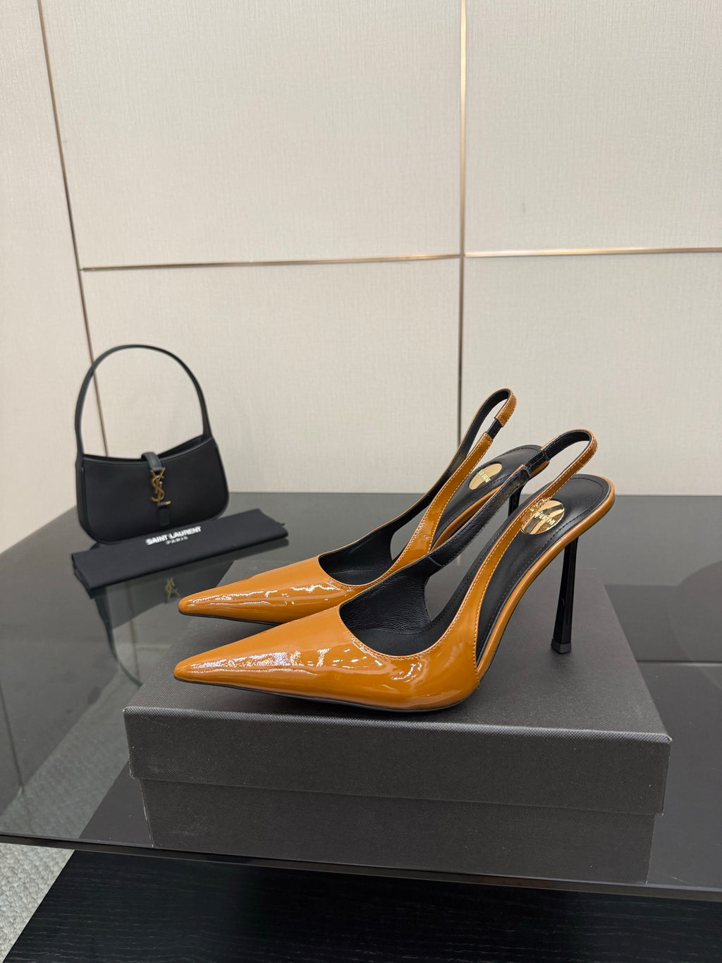 Women's glossy orange pointed-toe slingback pumps on black high stiletto heels.