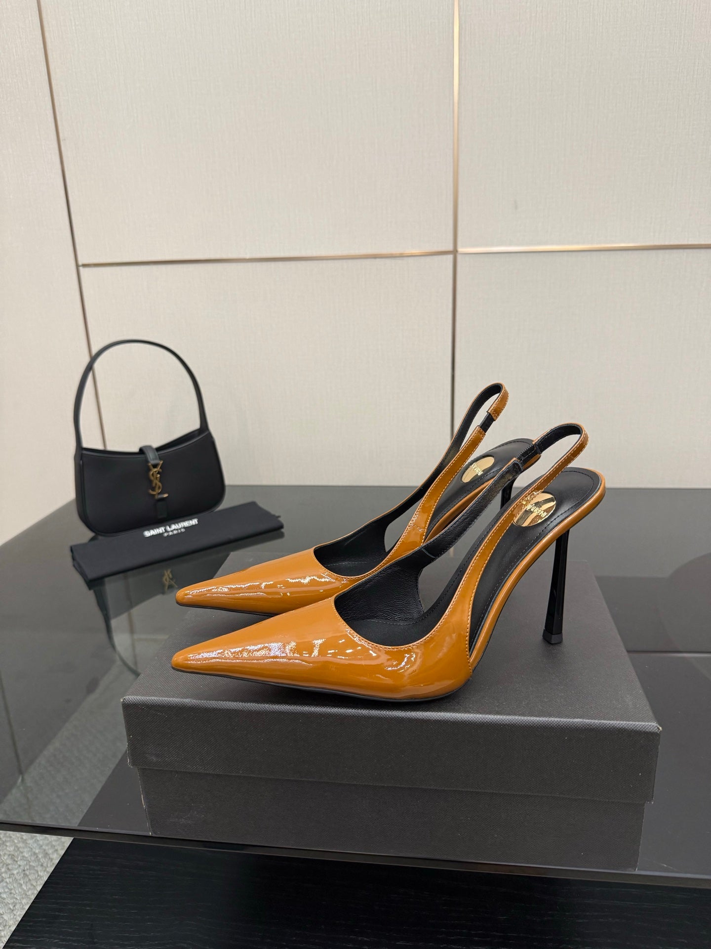 Women's glossy orange pointed-toe slingback pumps on black high stiletto heels.