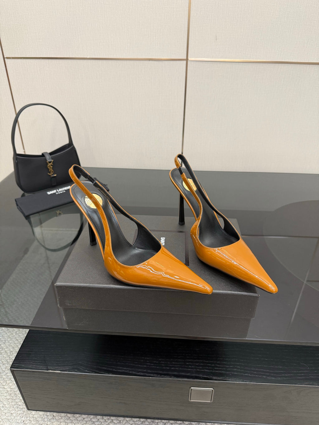 Women's orange pointed-toe slingback pumps with black interior and stiletto heels.