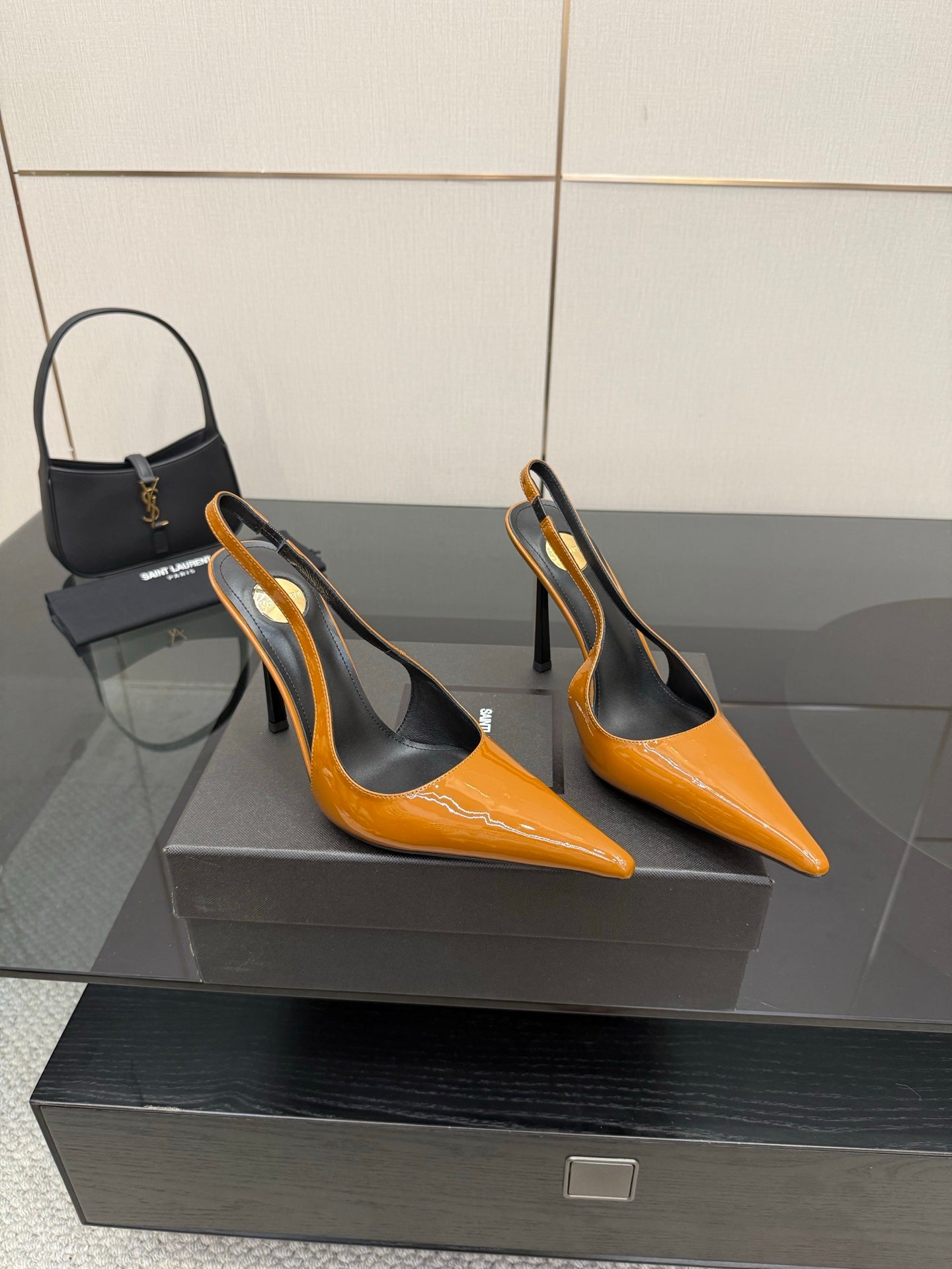 Women's orange pointed-toe slingback pumps with black interior and stiletto heels.