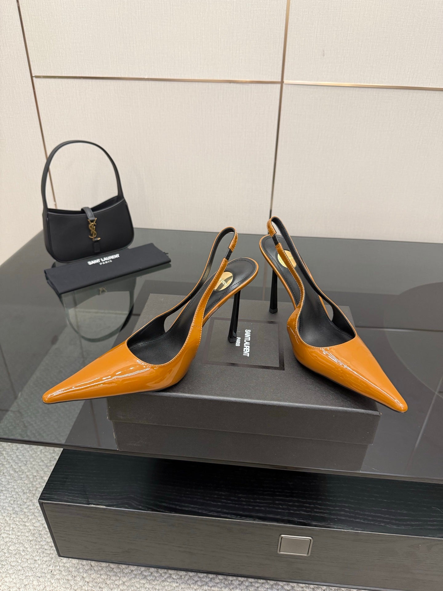 Women's orange pointed-toe slingback pumps with black heel counter and high stiletto.