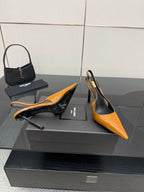 Women's orange patent slingback pumps with black insole and slim stiletto heel.