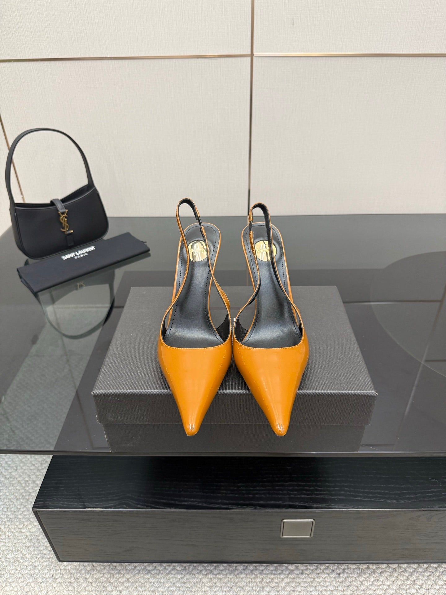 Women's orange-and-black pointed-toe slingback pumps with high stiletto heels.