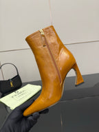 Tan leather ankle boot with high heel, pointed toe, and visible side zipper